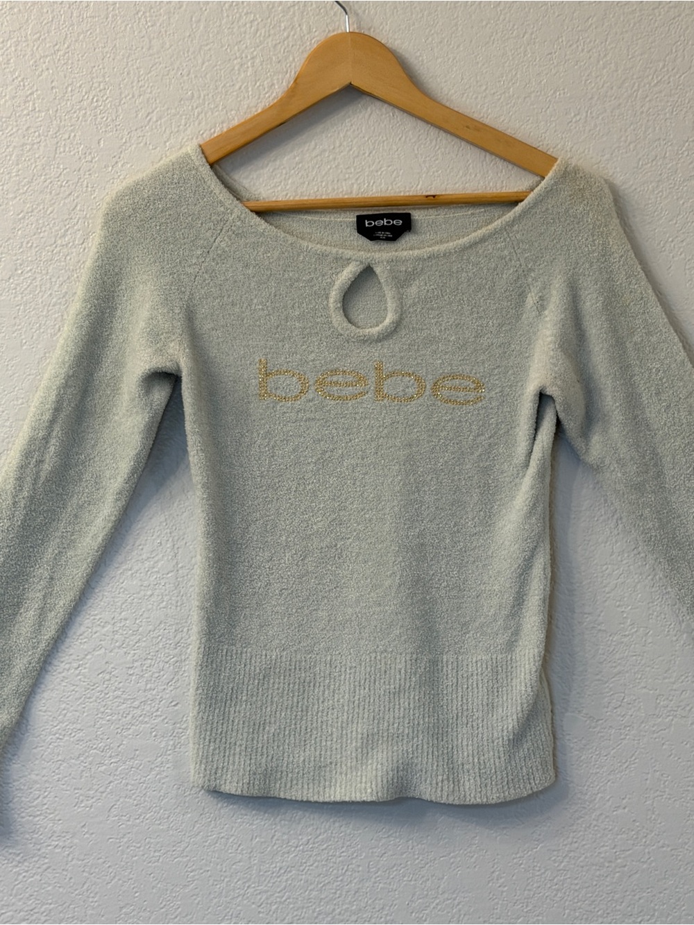 bebe Cream Off-Shoulder Sweater with Gold Logo